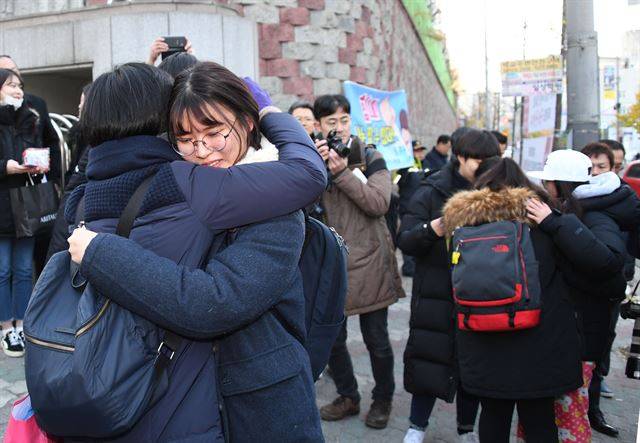 지진으로 수능이 일주일 연기됐던 지난해 11월 23일 오전 포항 이동중학교 고사장 앞에서 수험생들이 입실을 앞두고 포옹하고 있다. 한국일보 자료사진
