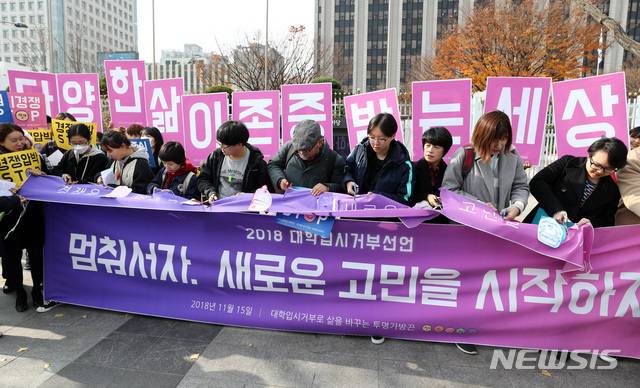 【서울=뉴시스】이영환 기자 = 15일 오후 서울 종로구 정부서울청사 앞에서 대학입시거부로 삶을 바꾸는 투명가방끈 관계자들이 행진을 마치고 가방끈 컷팅 퍼포먼스를 하고 있다. 2018.11.15.  20hwan@newsis.com