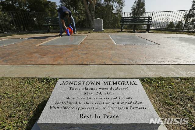 【오클랜드 = AP/뉴시스】 지난 10월 25일 오클랜드의 에버그린 묘지에서 인민사원 집단 자살사건의 희생자 900여명을 추모하는 기념판을 존스 목사의 양자였던 짐 존스 2세가 설치하고 있다.  11월 18일 집단 자살 40주기를 맞아 이 묘지에서는 가이아나의 밀림지대 '인민사원'에서 죽음을 맞은 뒤 이 곳에 묻힌 주민 400여명을 위한 추모행사가 열렸다.