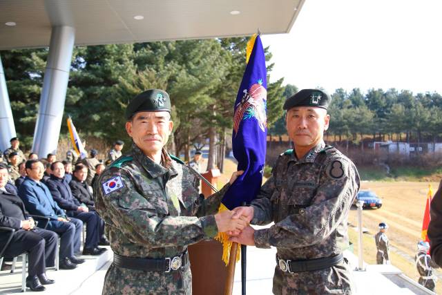 이정기 7군단장(육군 중장·왼쪽)이 30일 경기도 양주시 소재 26사단 본부 연병장에서 열린 8기계화보병사단·26기계화보병사단 통합개편식에서 통합 8사단 신임 사단장인 최진규 소장에게 지휘권을 이양한 뒤 부대기를 수여하고 있다./사진제공=육군 제8기계화보병사단