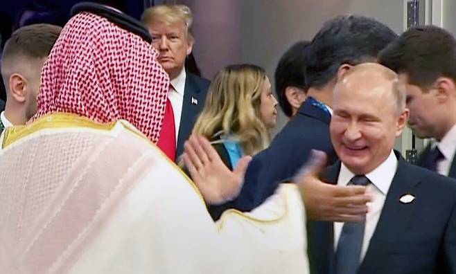 블라디미르 푸틴 러시아 대통령이 지난달 30일(현지시간) 아르헨티나 부에노스아이레스에서 열린 G20 정상회의에 참석, 무함마드 빈 살만 사우디아라비아 왕세자와 반갑게 인사하고 있다. 뒤편으로는 도널드 트럼프 미국 대통령이 보인다. [AFP=연합뉴스]