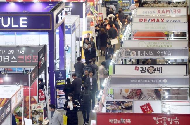 지난달 부산 해운대구 벡스코에서 열린 프랜차이즈부산에서 예비 창업자들이 창업과 관련한 전시장을 둘러보고 있다. [제공=연합사진]