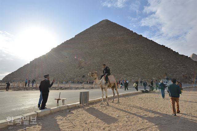 이집트 수도 카이로의 쿠푸피라미드 앞에서 경찰관들이 순찰 도중 얘기를 나누고 있다.