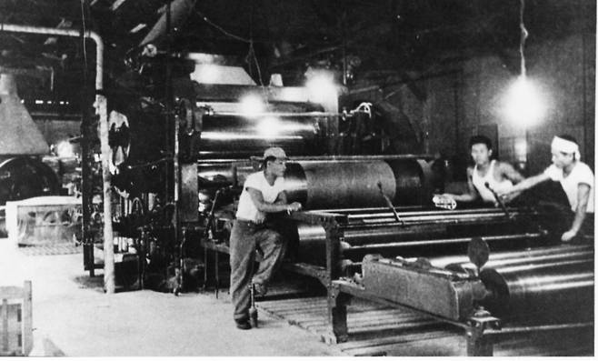 1954년 부산의 락희화학이 일본에서 들여온 기계로 국내 최초로 비닐장판을 만들고 있다.[중앙포토]
