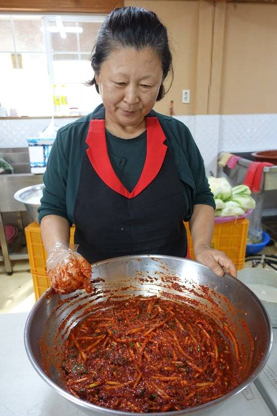 박광희 명인이 김칫소를 다 비빈 다음 색깔을 들여다보고 있다.