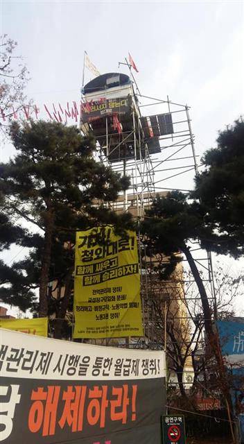 - 김 지회장이 2017년 9월 4일부터 ‘법인택시 전액관리제 시행 및 불법사납금제 폐지’를 촉구하며 농성을 벌이고 있는 25m 높이 조명탑을 먼발치에서 바라본 모습. 택시노조 전북지회 제공