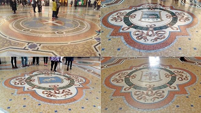 팔각광장의 바닥에는 3개의 이탈리아 왕국과 밀라노의 문장을 모자이크로 장식했다. 시계방향으로 밀라노(좌상), 로마(우상), 피렌체(우하) 그리고 토리노(좌하)의 문장이다. 특히 토리노의 문장에 새겨진 황소의 불알을 발뒤꿈치로 밟고 세 바퀴 돌면 행운이 온다고 해서 사람들이 줄을 잇는다.