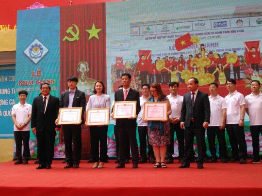 베트남 하노이공업전문대학에서 현대건설 하노이 메트로 3호선 현장 김도균 소장(사진 앞줄 왼쪽에서 네 번째), 코이카 베트남 사무소 임인영 부소장(왼쪽에서 세 번째) 등이 하노이 인민위원회로부터 'Recognition Certificate' 표창장을 수여받은 후 기념 사진을 촬영하고 있다. <현대건설 제공>