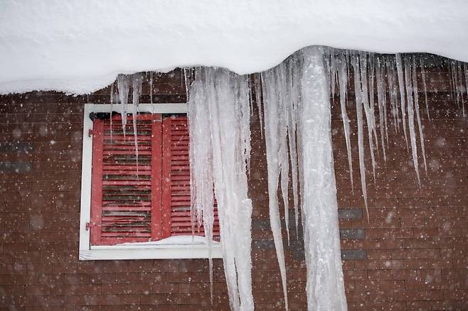 폭설이 내린 13일(현지시간) 스위스 관광도시 안데르마트의 한 가옥 처마에 고드름이 붙어 있다. 사진=AP/뉴시스