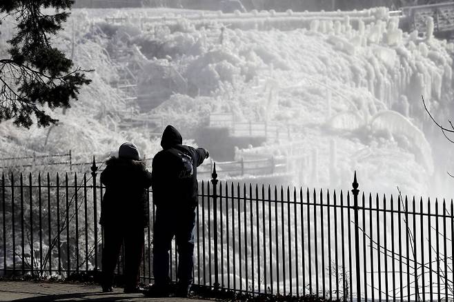 지난 29일(현지시간) 미국 뉴저지주 패터슨의 한 국립공원에서 시민들이 꽁꽁 얼어붙은 폭포를 바라보고 있다. 패터슨｜AP연합뉴스