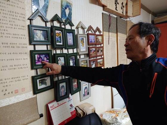 지난 11일 오후 '혜희양 아빠' 송길용씨가 벽에 걸린 혜희양 사진을 어루 만지고 있다. 김민욱 기자