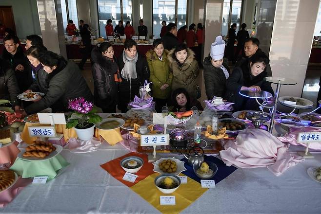 13일 북한 평양에서 열린 전국 요리 경연대회에서 방문객들이 다양한 지역별 출품 요리를 살펴보고 있다.  평양/AFP 연합뉴스