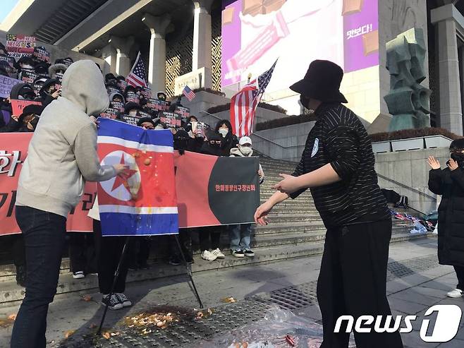 한미동맹연구청년회가 17일 오후 서울 종로구 세종문화회관 앞에서 열린 '한미동맹 강화 요구 집회'에서 인공기에 날계란을 던지는 퍼포먼스를 벌이고 있다. 2019.2.17/뉴스1 © 뉴스1 박혜연 기자