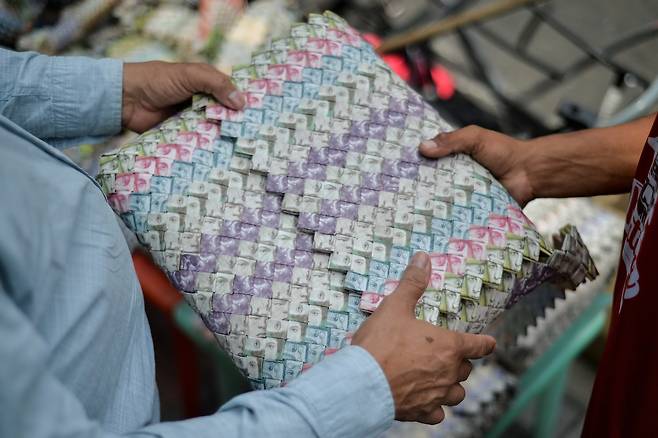 콜롬비아 쿠쿠타에서 한 남성이 베네수엘라 지폐로 만든 가방을 살펴보고 있다. [AFP=연합뉴스]