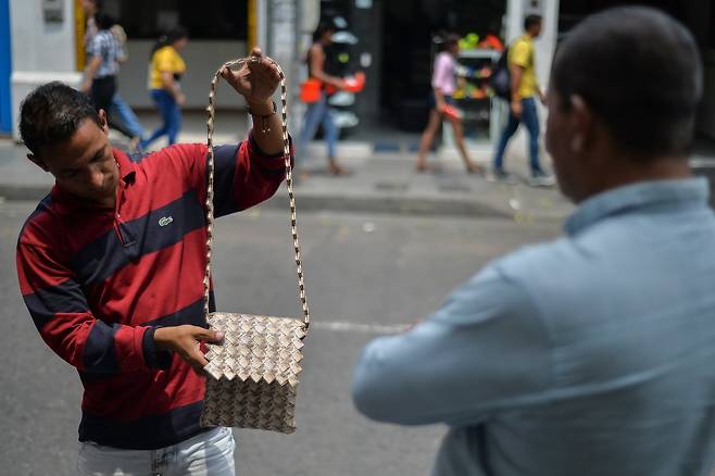 콜롬비아 쿠쿠타에서 한 남성이 베네수엘라 지폐로 만든 가방을 살펴보고 있다. [AFP=연합뉴스]