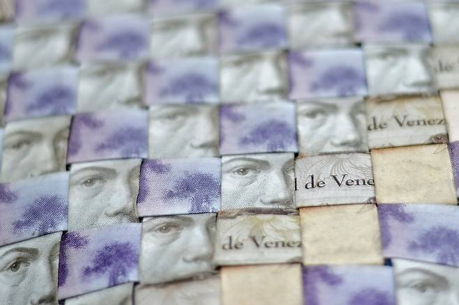 가방은 지폐를 잘라서 격자로 무늬로 엮어 만들었다. 베네수엘라 나라 이름과 위인의 얼굴이 보인다.[AFP=연합뉴스]