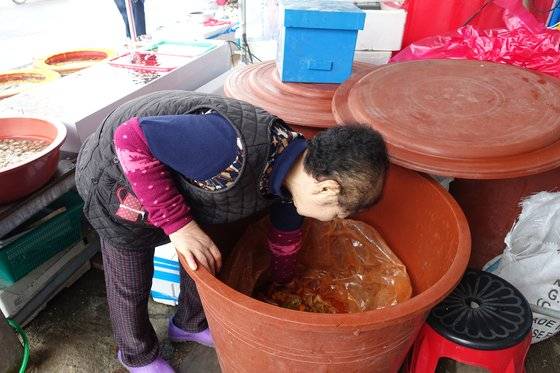 서산 동부시장 백반집 여주인 김씨가 게국지 통 안을 살펴보고 있다.