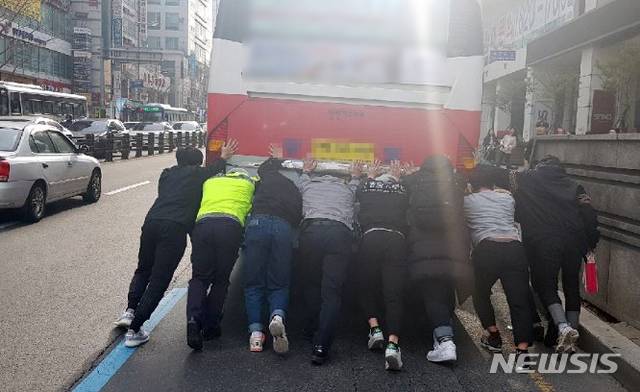【부산=뉴시스】 지난 9일 부산 남구 경성대 앞 교차로에서 고장으로 멈춰선 좌석버스를 경찰과 시민 등이 힘을 합쳐 이동시키고 있다. 2019.03.11. (사진=부산경찰청 제공)photo@newsis.com