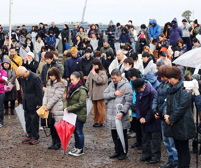 11일 동일본 대지진으로 많은 희생자가 난 일본 미야기 현 나토리 시 유리아게 지구에 모인 시민들이 지진 발생시간에 맞춰 묵념을 하고 있다. [지지통신]