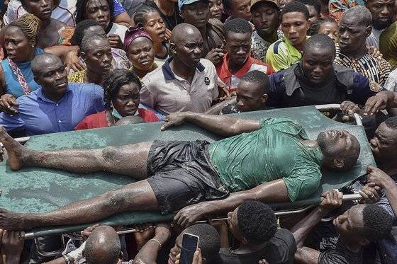 나이지리아 라고스 이타파지에서 학교가 입주해 있는 건물이 13일(현지시간) 오전 9시 붕괴했다. 현지주민들이 건물에 매돌됐던 학생을 구조하고 있다. [EPA=연합뉴스]