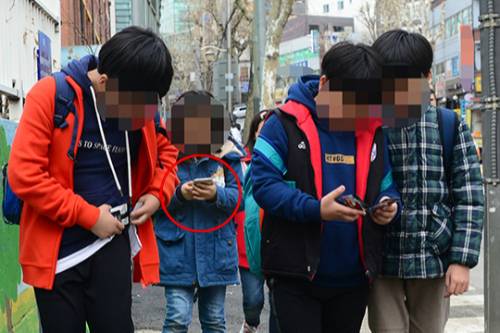 스마트 폰을 보거나 친구들과 함께 게임을 하면서 걷고 있는 학생들. 세계일보 자료사진