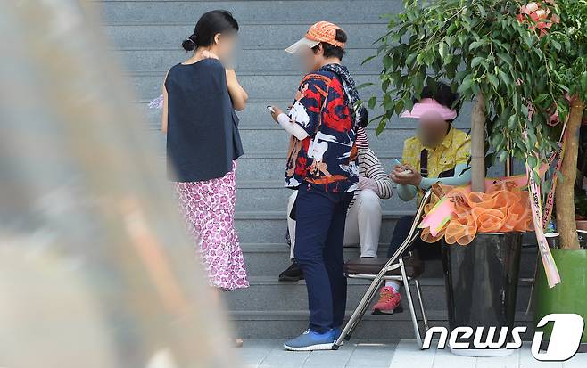 모델하우스 앞에서 이동식 부동산 중개업소 직원들이 청약 당첨자와 대화를 하고 있다. 국토교통부는 지난해부터 불법전매 단속을 실시한다고 있다. /뉴스1