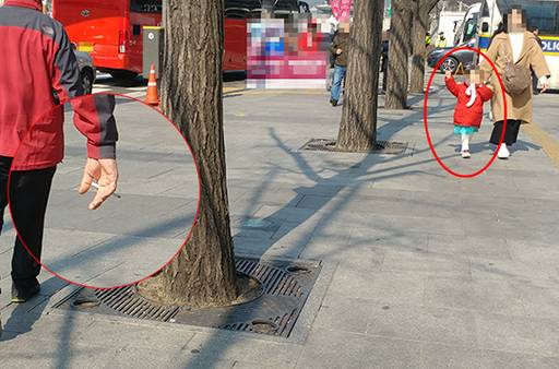 한 아이의 손을 잡고 걷던 한 주부는 담배를 피우며 걷는 흡연자를 보자 머뭇대다 멀찌감치 떨어져 걷고 있다.