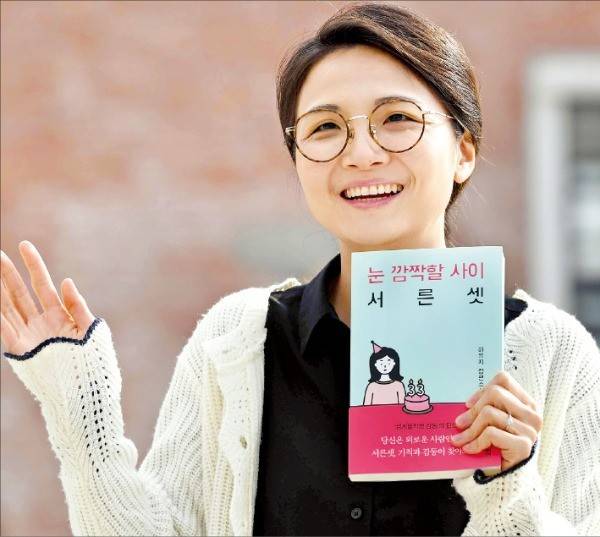 소설가 하유지 씨가 새 장편소설 《눈 깜짝할 사이 서른셋》을 들어보이며 웃고 있다. /김범준 기자 bjk07@hankyung.com