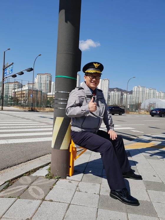 노인 보행 사고를 막기 위해 장수의자를 개발한 유석종 별내파출소장. 그가 1일 장수의자에 앉아 환하게 웃어보이고 있다.［사진 별내파출소］
