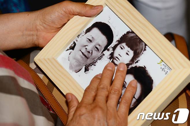 지난 2017년 5월 열린 제11회 실종아동의 날 행사에서 실종 아동 신경하(실종당시 만5세)의 어머니인 한태순 씨가 아이 사진을 어루만지고 있다. © News1 임세영 기자