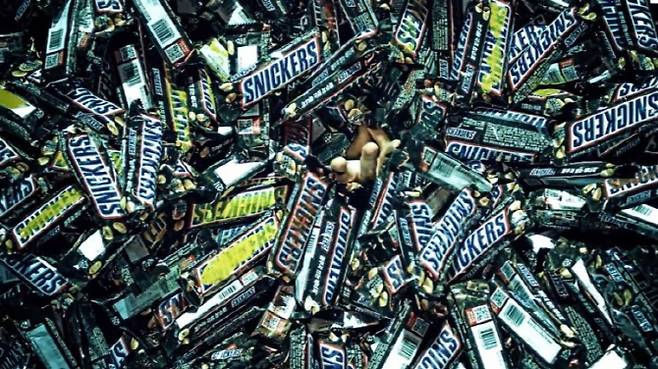 방탄소년단의 ‘fake love’ 뮤직비디오에서 호석이 초코바에 가득 둘러싸있는 장면. 초코바는 호석을 버리고 간 어머니에 대한 아픈 기억, 트라우마를 상징하는 물건으로 거짓과 불행을 의미한다.