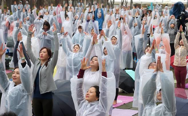 롯데백화점은 14일 창립 40주년을 기념해 전세계에서 가장 큰 요가행사인 '요가 말라 프로젝트'를 유통업계 최초로 개최했다. 이날 비가 내리는 가운데 500여명의 요가 애호가들이 롯데백화점 잠실점 월드파크에서 '108 수리야나마스카라'를 하고 있다. 최정동 기자