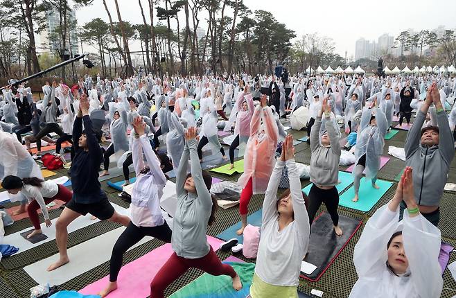 롯데백화점은 14일 창립 40주년을 기념해 전세계에서 가장 큰 요가행사인 '요가 말라 프로젝트'를 유통업계 최초로 개최했다. 이날 비가 내리는 가운데 500여명의 요가 애호가들이 롯데백화점 잠실점 월드파크에서 '108 수리야나마스카라'를 하고 있다. 최정동 기자