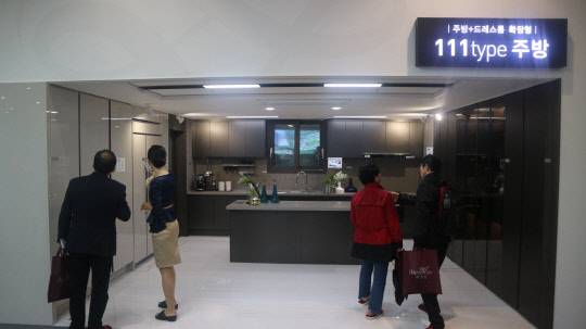 송파 위례 리슈빌 퍼스트클래스 111㎡ 타입 주방+드레스룸 확장형 모형을 관람하고 있는 방문객들의 모습. <이상현 기자>