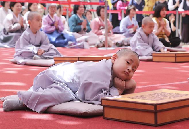 한 동자승이 수계식 중 졸음을 참지 못하고 잠시 눈을 붙이고 있다.   임현동 기자