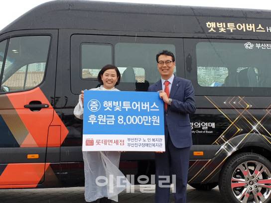 롯데면세점 부산점이 부산지역 교통약자의 이동권을 보장하기 위해 15인승 미니버스를 부산 진구 노인장애인복지관에 기부했다. 허기 롯데면세점 부산점장(오른쪽)과 서은숙 부산광역시 진구청장이 햇빛투어버스 기증 행사를 진행한 후 기념사진을 촬영하고 있다. (사진=롯데면세점)