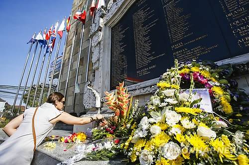 2014년 10월 12일 인도네시아 발리섬 쿠타 지역에 건립된 2002년 발리 폭탄 테러 추모비를 찾은 유가족들이 희생자들을 기리고 있다. [EPA=연합뉴스자료사진]