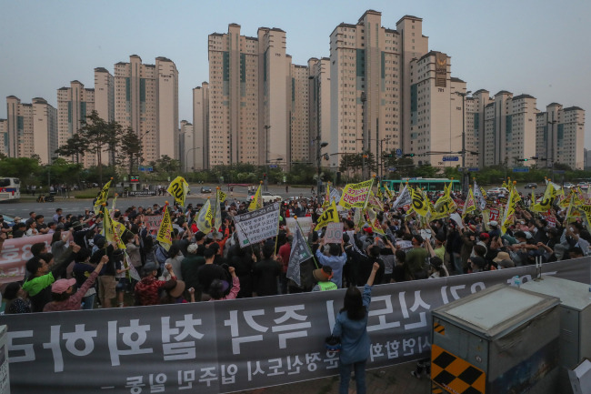 12일 경기도 파주시 운정행정복지센터 앞에서 고양 일산신도시 연합회와 파주 운정신도시 연합회, 인천 검단 신도시 연합회 주민들이 집회를 열고 3기 신도시 계획을 규탄하는 구호를 외치고 있다. [연합]