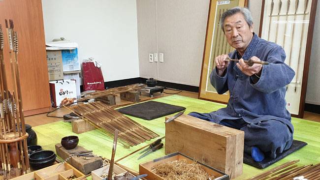 국가무형문화재 47호 궁시장 박호준 보유자가 깎고 다듬어 완성한 화살이 제대로 잘 만들어졌는지 살펴보고 있다. 작은 사진은 화살 재료인 신우대를 다듬는 장면.