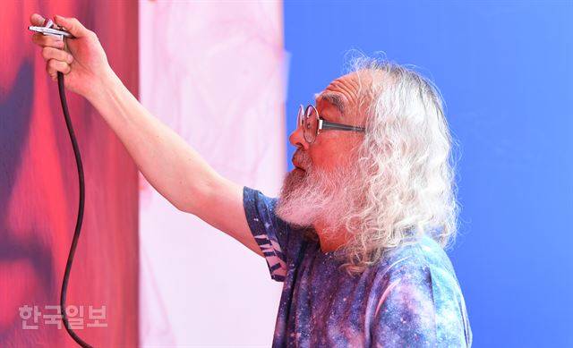 [저작권 한국일보] 14일 오후 서울 중구 필동의 길거리전시장 '사변삼각'에서 강형구 화백이 자신의 붉은 자화상을 그리고 있다. 에어브러쉬로 물감을 쏘는 모습이다. 홍윤기 인턴기자
