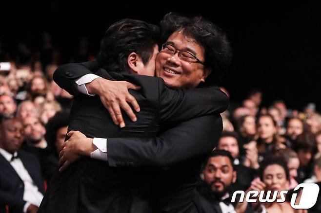 (AFP=뉴스1) 포토공용 기자 = 봉준호 감독이 25일(현지시각) 프랑스 칸 뤼미에르 극장에서 열린 제72회 칸국제영화제(칸영화제) 폐막식에서 최고상인 황금종려상을 수상한 후 배우 송강호와 포옹을 하고 있다.   한국 영화가 칸영화제 최고상인 황금종려상을 받은 것은 이번이 처음이다. 또한 우리나라 영화가 칸영화제 본상 수상에 성공한 것은 지난 2010년 제63회 칸영화제에서 각본상을 받은 이창동 감독의 '시' 이후 9년 만이다. 2019.5.26/뉴스1  © AFP=뉴스1  <저작권자 © 뉴스1코리아, 무단전재 및 재배포 금지>