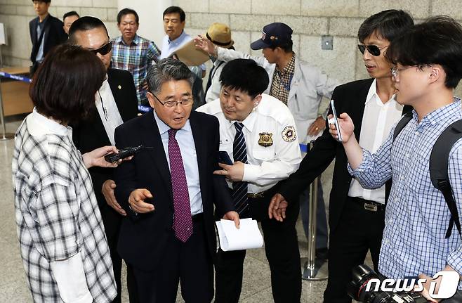 지난 16일 5·18 관련 단체 회원들의 항의 받으며 서울중앙지법 들어서는 지만원씨. 뉴스1DB © News1 오대일 기자