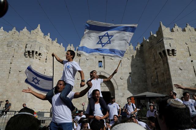 1967년 제3차 중동전쟁(이른바 6일 전쟁)  중 예루살렘을 탈환한 것을 기념하는 '예루살렘의 날'을 맞은 2일(현지시간) 이스라엘 예루살렘 올드시티의 다마스쿠스 문 앞에서 유대인 청년들이 이스라엘 국기를 흔들며 기념 행진을 하고 있다.  로이터 연합뉴스