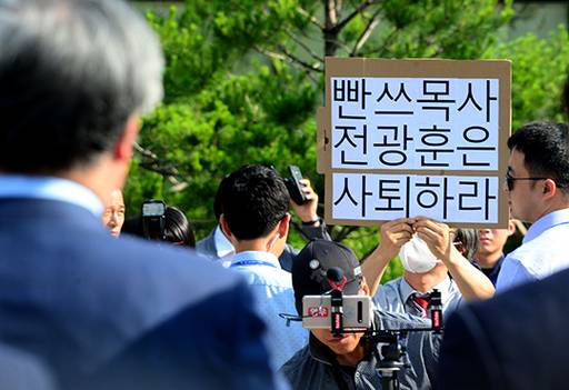문재인 대통령에게 공개적으로 하야를 요구해 논란을 빚은 한국기독교총연합회 대표회장 전광훈 목사가 지난 11일 오후 청와대 분수대 앞에서 기자회견을 열고 발언하고 가운데 한 시민이 ‘빤쓰목사 전광훈은 사퇴하라’고 쓰인 피켓을 들고 있다.
