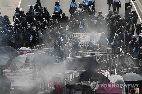 시위대와 충돌하는 홍콩 경찰 (홍콩 AFP=연합뉴스) 12일 홍콩 정부청사 건물 주변에서 경찰이 '범죄인 인도 법안'에 반대하는 시위대와 충돌하고 있다. leekm@yna.co.kr