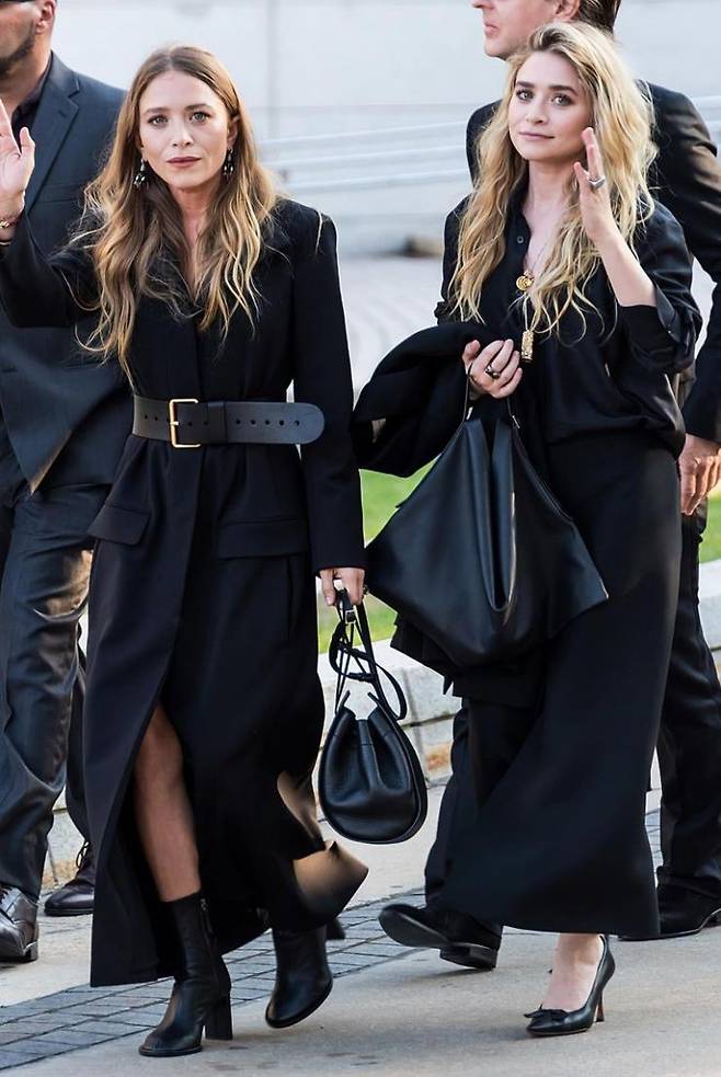 2018년 6월 4일 시크함이란 이런 것. 오버사이즈 벨트로 군더더기 없는 코트 스타일링과 내추럴하게 풀어 해친 셔츠로 관능적인 매력을 뽐내는 자매.