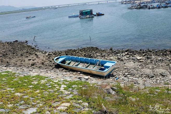 부산 강서구의 한 포구 인근 해안에 소형 FRP 선박 한 척이 버려져 있다. (사진=박진홍 수습기자)
