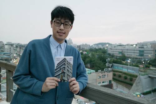 지난 20일 오후 서울 서대문구 창천동의 한 카페에서 '서울의 현대를 찾아서' SNS를 운영하는 김영준 씨가 자신이 펴낸 사진집 '서울의 정말 오래된 빌딩들'을 손에 든 채로 서 있다. [사진 출처 = 박동우 인턴기자]