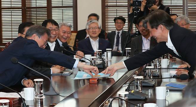 문재인 대통령이 지난해 1월22일 오후 청와대 여민관에서 열린 대통령주재 수석보좌관 회의에서 조국 민정수석한테서 과자를 건네 받고 있다. 청와대 사진기자단