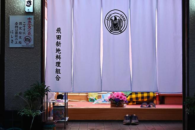 일본 오사카 시의 홍등가인 '토비타신치'의 한 점포에 26일 흰 커튼이 내려져 있다. 토비타신치 협동조합은 성공적인 G20 개최를 위해 쇼 윈도를 가린 채 영업할 예정이며, 회담일인 28일과 29일에는 임시 휴업할 것이라고 밝혔다. [AFP=연합뉴스]